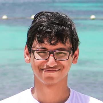 Abir, a brown man with black short hair is smiling at the camera. He wears glasses and a white tshirt.